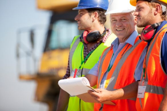 a group of construction workers discuss plans