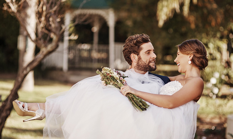A groom carrie his bride after a wedding