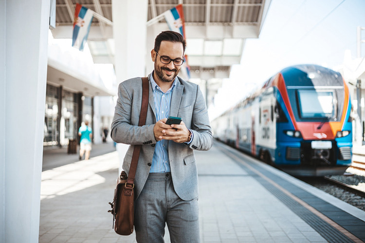a business man walks outside of a train station